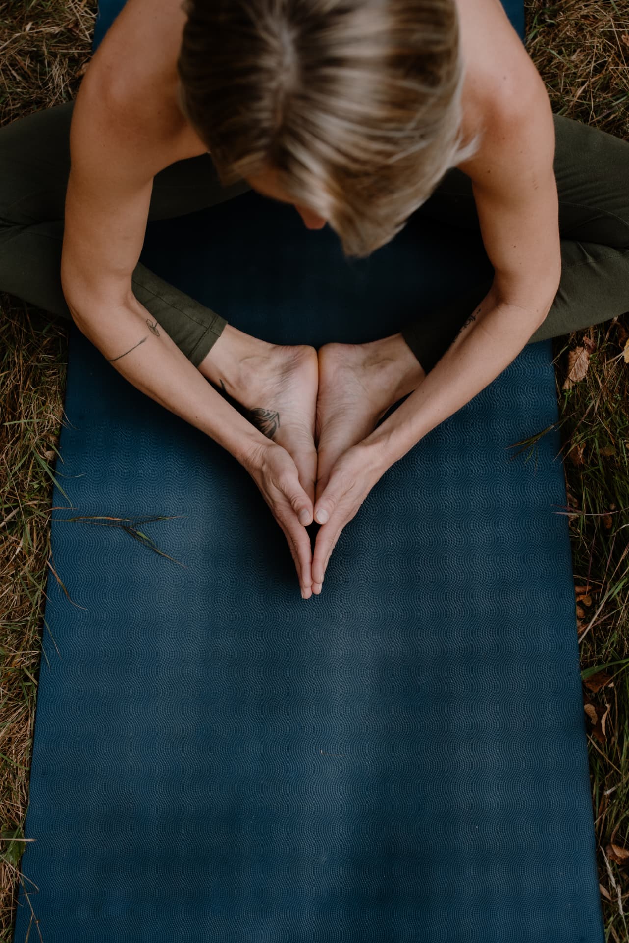 Hände und Füße auf einer Yogamatte in Schmetterlingshaltung